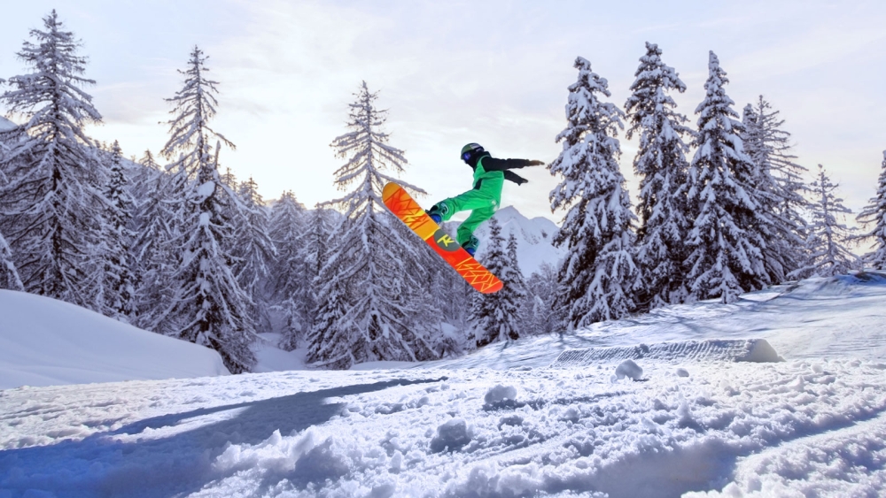 Man jumping while snowboarding at Powder Ridge